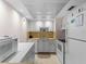 Compact kitchen featuring white appliances, a stainless steel sink, and ample cabinet space at 72 Boundary Blvd # 226, Rotonda West, FL 33947