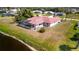 Home featuring screened lanai overlooking waterfront, expansive yard, and neutral exterior at 730 Boundary Blvd, Rotonda West, FL 33947
