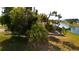 Waterfront backyard view with lush tropical landscaping and screened lanai for outdoor living at 730 Boundary Blvd, Rotonda West, FL 33947