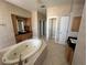 Bright bathroom featuring a large soaking tub, wood cabinets, and a black granite countertop at 730 Boundary Blvd, Rotonda West, FL 33947