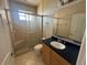 Bathroom featuring a glass-enclosed shower, toilet, and sink with vanity, designed for functionality at 730 Boundary Blvd, Rotonda West, FL 33947