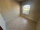 Neutral bedroom with tile flooring and a large arched window letting in natural light at 730 Boundary Blvd, Rotonda West, FL 33947