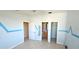 Bedroom with bathroom, closet entrances, tile flooring, ceiling fan and three arched windows at 730 Boundary Blvd, Rotonda West, FL 33947
