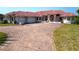 Sprawling single-Gathering home boasting a vibrant red tile roof and circular driveway at 730 Boundary Blvd, Rotonda West, FL 33947