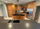 View of the kitchen featuring an island with black countertops, stainless steel appliances and custom wood cabinets at 730 Boundary Blvd, Rotonda West, FL 33947