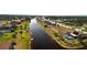 Aerial view of a waterfront community with lush landscaping and well-maintained homes along a canal at 730 Boundary Blvd, Rotonda West, FL 33947