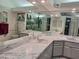 Bright, tiled bathroom featuring dual sinks, large mirrors, and recessed lighting at 2575 Brazilia Ct, Punta Gorda, FL 33950