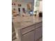 Close up of modern kitchen showing light grey cabinetry, marble countertop, white appliances, and sink with brushed nickel fixtures at 2575 Brazilia Ct, Punta Gorda, FL 33950