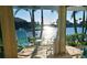 Relaxing lanai with chairs, side table, and serene canal views framed by swaying palm trees at 2575 Brazilia Ct, Punta Gorda, FL 33950