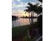Sunset water view featuring palm trees and green grass at 2575 Brazilia Ct, Punta Gorda, FL 33950
