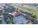Aerial view of the community amenities including a pool, tennis court and lush landscaping at 10203 Windsong Rd, Punta Gorda, FL 33955