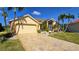 Beautiful single-story home featuring a well-manicured lawn, concrete driveway, and tan-colored paint at 10203 Windsong Rd, Punta Gorda, FL 33955