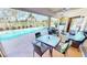 Covered patio with ample seating overlooking the sparkling pool and scenic lake views at 10203 Windsong Rd, Punta Gorda, FL 33955
