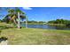 Picturesque water view featuring a tranquil pond, framed by palm trees and manicured lawn at 10203 Windsong Rd, Punta Gorda, FL 33955