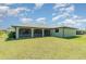 Exterior of home highlighting a spacious, grassy backyard and screened lanai at 1069 Fergus Ln, Punta Gorda, FL 33983