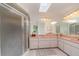 Bright bathroom featuring a skylight, walk-in shower, large mirror, and dual sinks at 1069 Fergus Ln, Punta Gorda, FL 33983