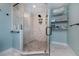Modern walk-in shower with marble tiling, stone floor, and a built-in shelving unit for storage at 12420 Minot Ave, Port Charlotte, FL 33981