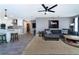 Comfortable living room with gray sectional sofa, area rug, ceiling fan, and access to the kitchen and other rooms at 12420 Minot Ave, Port Charlotte, FL 33981