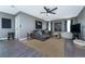 Spacious living room with stylish decor, gray sectional, large area rug, and modern ceiling fan at 12420 Minot Ave, Port Charlotte, FL 33981