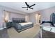 Inviting main bedroom with a large bed, mirrored furniture, ceiling fan, and access to an ensuite bathroom at 12420 Minot Ave, Port Charlotte, FL 33981