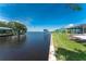 Beautiful water view with a private dock, lush grass and screened in patio at 12420 Minot Ave, Port Charlotte, FL 33981