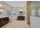 A luxurious bathroom with a soaking tub, dual vanities, plantation shutters, and tiled shower at 12472 Davie Ct, Venice, FL 34293