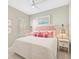 Cozy bedroom with a white comforter and colorful decorative pillows and an ocean-themed picture on the wall at 12472 Davie Ct, Venice, FL 34293