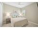 Comfortable bedroom featuring a ceiling fan, neutral decor, side tables with lamps, and plantation shutters at 12472 Davie Ct, Venice, FL 34293