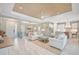 Open-concept living room, dining, and kitchen area with a decorative ceiling and tile flooring at 12472 Davie Ct, Venice, FL 34293