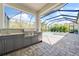 This stunning outdoor kitchen with built-in grill overlooks the screened-in pool and patio area at 12472 Davie Ct, Venice, FL 34293