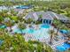 Aerial view of the community pool area with tropical landscaping and comfortable lounge seating at 12472 Davie Ct, Venice, FL 34293