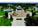 Aerial view of the community playground with covered seating, slides, swings, hopscotch, and ample green space at 12656 Sagewood Dr, Venice, FL 34293