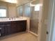 Bathroom featuring double vanity, framed mirrors, and glass enclosed shower with tiled walls at 12656 Sagewood Dr, Venice, FL 34293