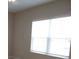 Bright bedroom featuring neutral walls and flooring, with a window providing natural light at 12656 Sagewood Dr, Venice, FL 34293