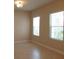 A well-lit bedroom with neutral walls, tile flooring, and two windows with blinds at 12656 Sagewood Dr, Venice, FL 34293