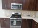 Modern kitchen features stainless steel appliances, dark cabinetry, and a stylish backsplash at 12656 Sagewood Dr, Venice, FL 34293
