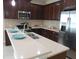 Spacious kitchen with stainless steel appliances, dark wood cabinets, and an island with a breakfast bar at 12656 Sagewood Dr, Venice, FL 34293
