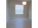 A light-filled living room with neutral walls, tile flooring, and a modern light fixture at 12656 Sagewood Dr, Venice, FL 34293