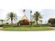 Beautiful clubhouse entrance with manicured landscaping and palm trees at 1677 Palace Ct, Punta Gorda, FL 33980