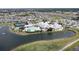 An aerial view shows the community pool, tennis courts, and recreation area on the lake at 1677 Palace Ct, Punta Gorda, FL 33980