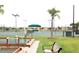 Community tennis courts with players, palm trees, lighting, and lush landscaping at 1677 Palace Ct, Punta Gorda, FL 33980