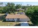 Aerial view of house including front yard with long driveway, two-car garage, and fenced-in backyard at 18459 Inwood Ave, Port Charlotte, FL 33948