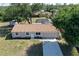 Aerial view of a home featuring a garage, well-manicured lawn, and mature trees at 18459 Inwood Ave, Port Charlotte, FL 33948