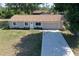 Aerial view of house including front yard with long driveway, two-car garage, and manicured flower beds at 18459 Inwood Ave, Port Charlotte, FL 33948