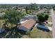 Aerial view of a charming home with a screened-in pool, lush greenery, and a long driveway at 18459 Inwood Ave, Port Charlotte, FL 33948