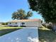 Front exterior view of home featuring long driveway, two-car garage, and front yard with green grass at 18459 Inwood Ave, Port Charlotte, FL 33948