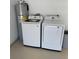 Garage setup with a washer, dryer, and water heater, and storage at 18459 Inwood Ave, Port Charlotte, FL 33948