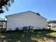 Side of home with AC unit surrounded by mulched flower bed and green grass at 18459 Inwood Ave, Port Charlotte, FL 33948