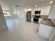 Open concept kitchen featuring stainless steel appliances, white cabinets, and marble floors at 18459 Inwood Ave, Port Charlotte, FL 33948
