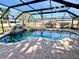 Relaxing screened pool area with unique rock features and a sparkling spa at 18459 Inwood Ave, Port Charlotte, FL 33948